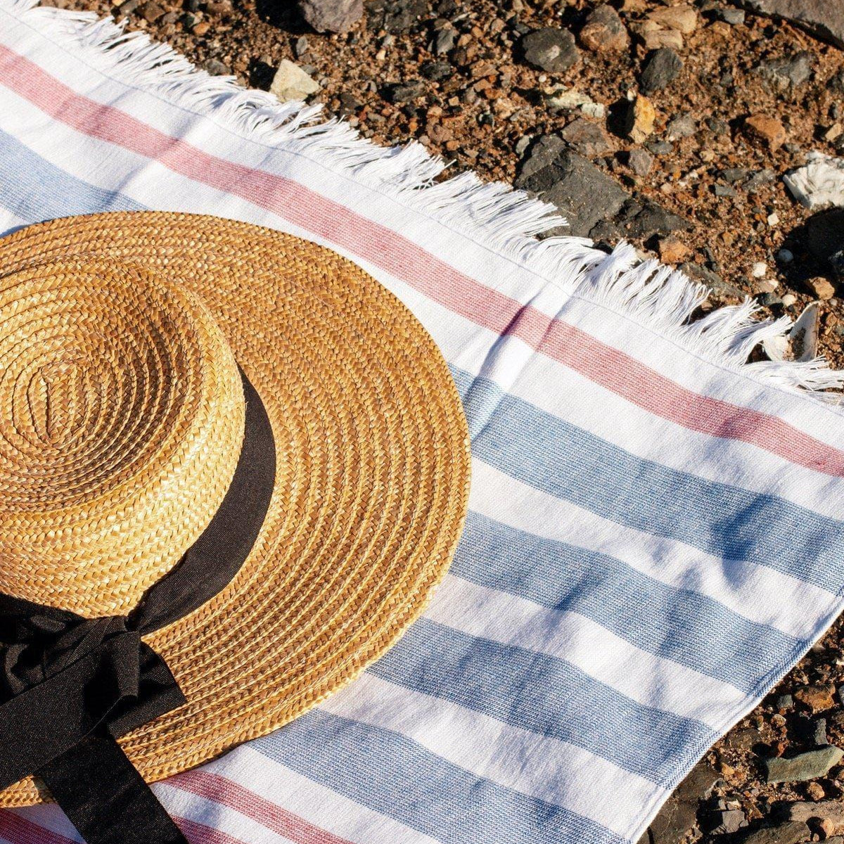 Luzia Peshtemal Beach and Pool Towel Blue and Red Cabana Stripes Shown at Seaside